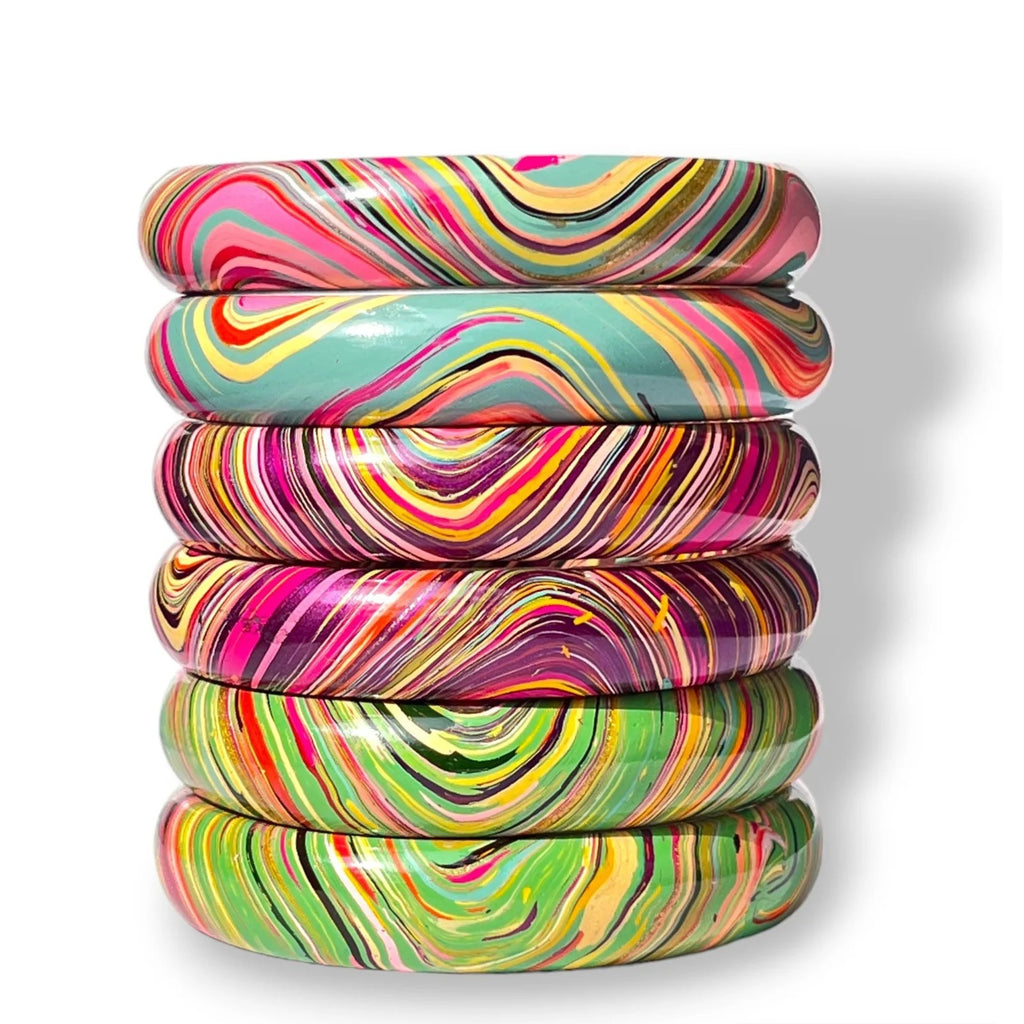 A stack of six glossy bangles with vibrant, multicolored swirl patterns in pink, yellow, green, purple, orange, and teal, set against a clean white background.