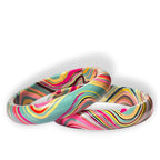 Two silicone wristbands with a vibrant, swirling marbled pattern in pink, teal, yellow, orange, and black, displayed on a clean white background.