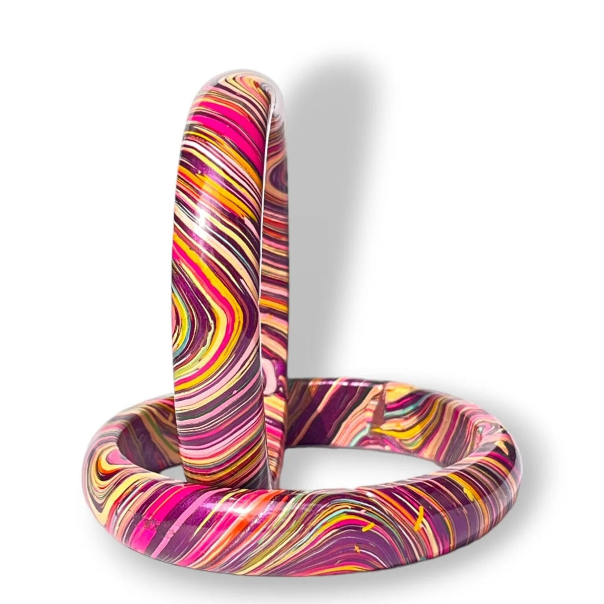 A pair of thick bangles with a vibrant marbled swirl pattern in pink, purple, yellow, orange, and white, displayed on a clean white background.